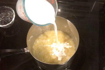 Poring whole milk into the roux